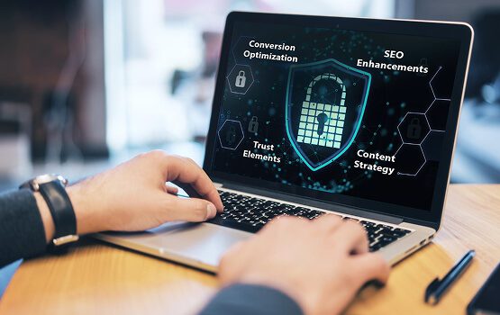 A close-up of a person's hands working on a laptop with a digital security shield on the screen, illustrating the technical features for secure digital marketing.