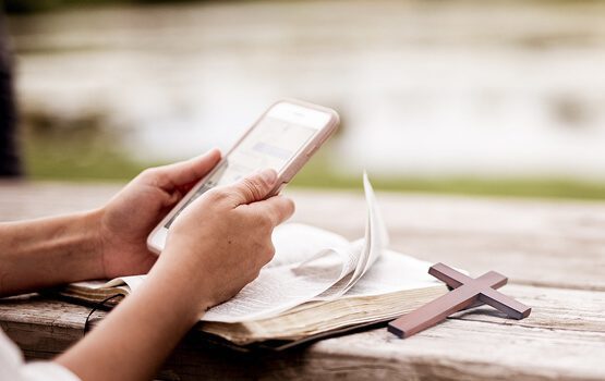 A person using a smartphone and pointing, with a glow of light emanating from the phone, illustrating the mobile-friendly design and digital features for user engagement.