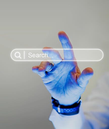 smiling young man using mobile phone while sitting laptop