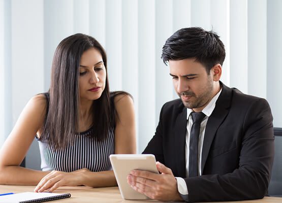 Two professionals discussing a project intensely over a laptop, symbolizing consulting, strategy, and collaborative project planning for digital marketing.