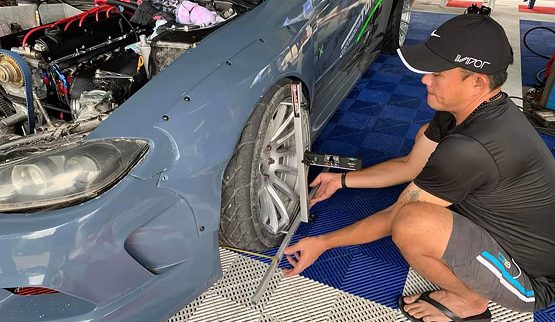 Wisitech case study image showing a mechanic using QuickTrick Alignment tools on a sports car wheel, highlighting Automotive Accessories and the digital strategy partnership.